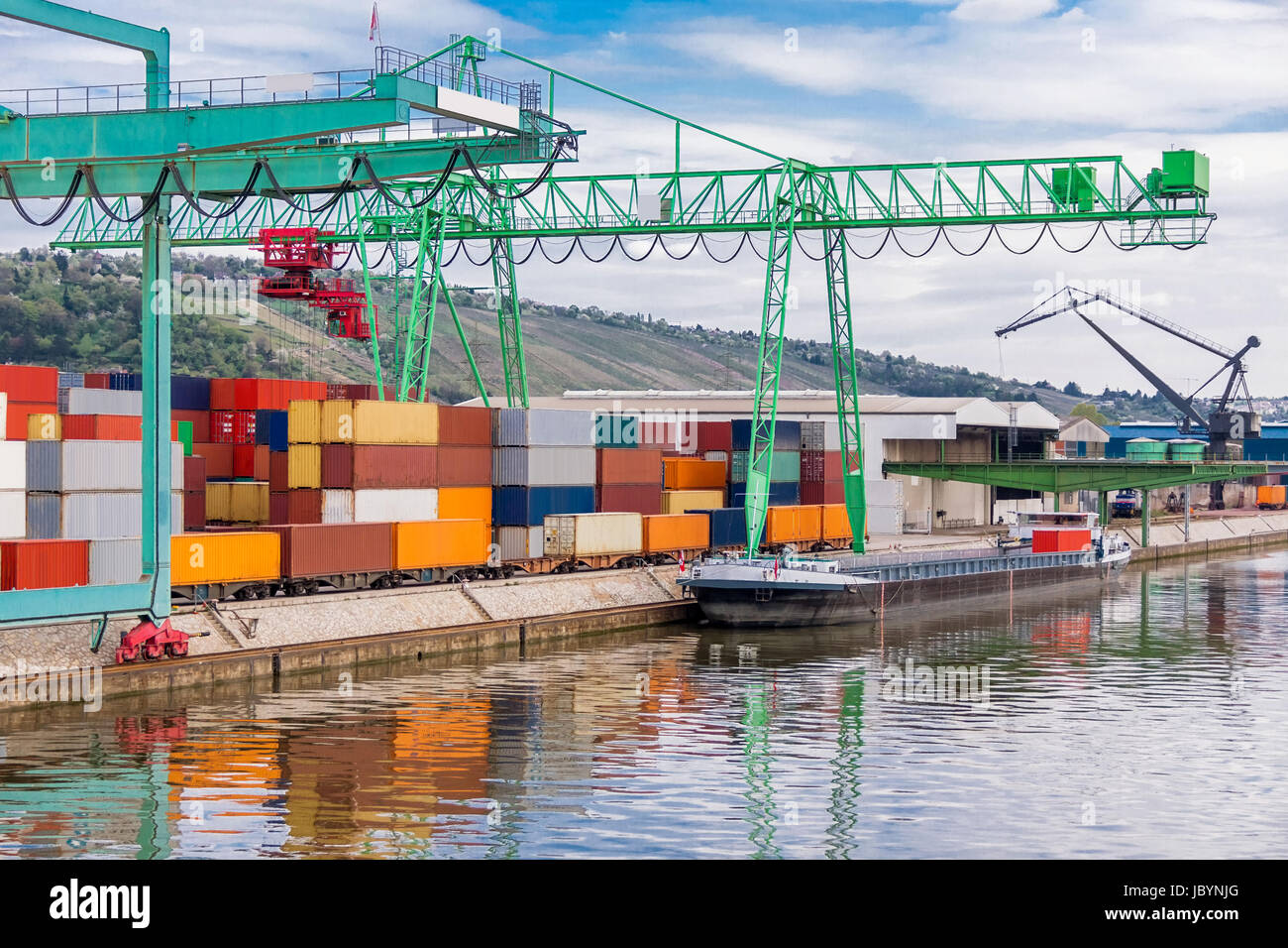 Anlegestelle im Hafen mit gestapelten Containern am Dock für Import und Export Cargo mit blauem Himmel Stock Photo