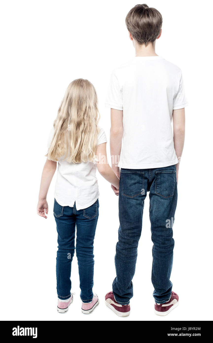 Rear view of young brother and sister with holding hands Stock Photo ...