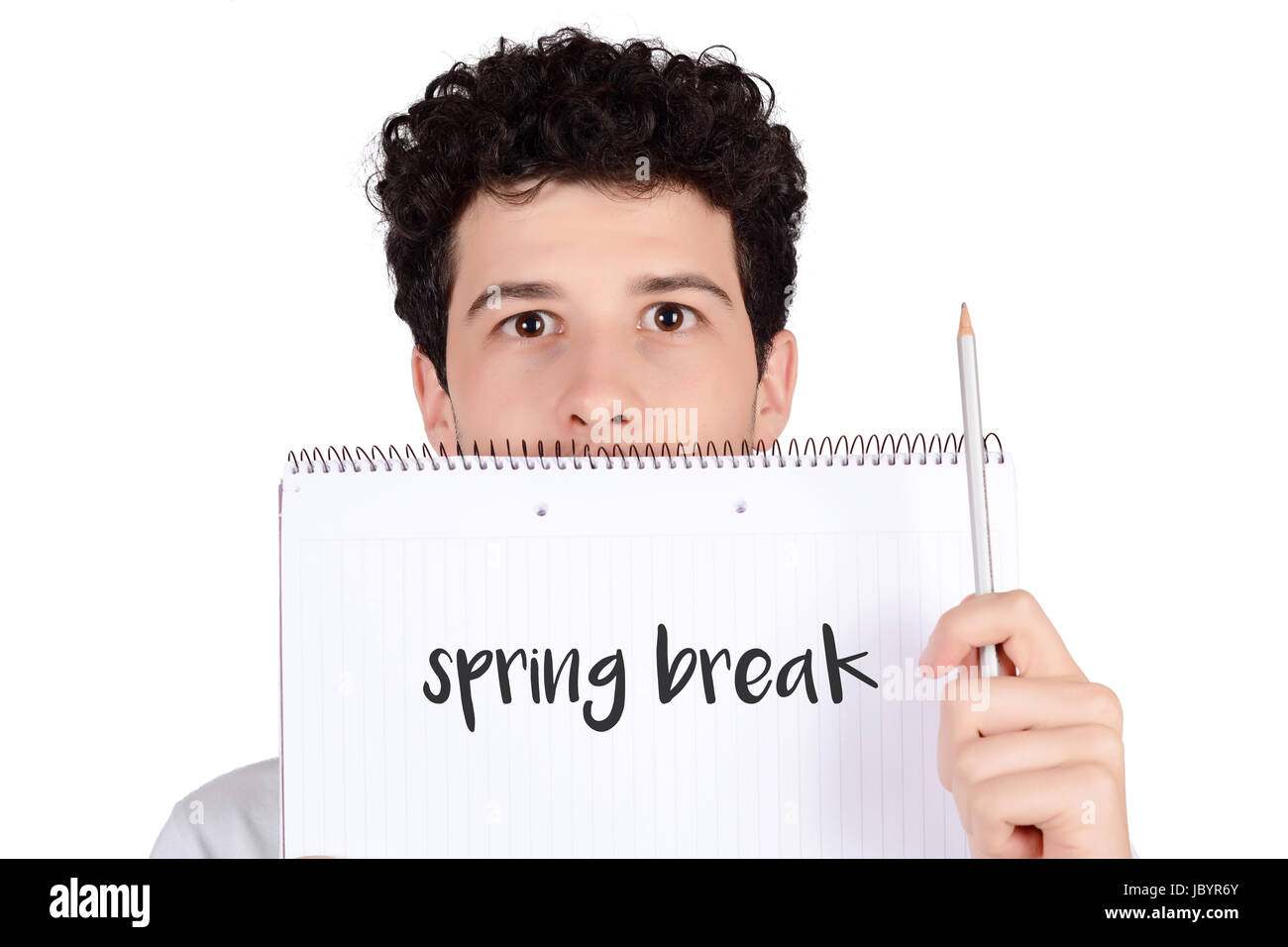 Close up of a young student holding notebook and pencil. Isolated white background. Stock Photo