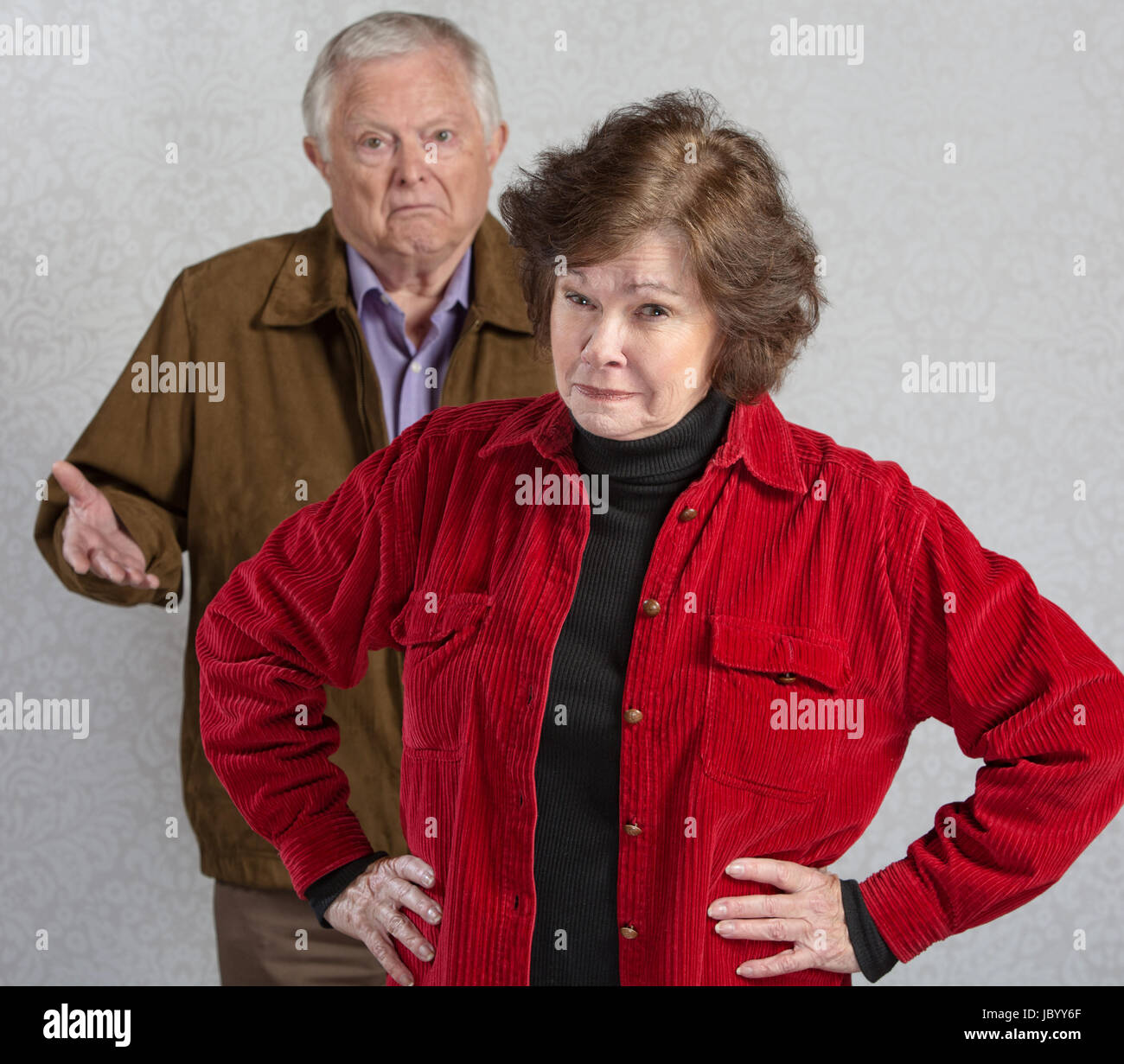 Suspicious senior woman in front of confused man Stock Photo