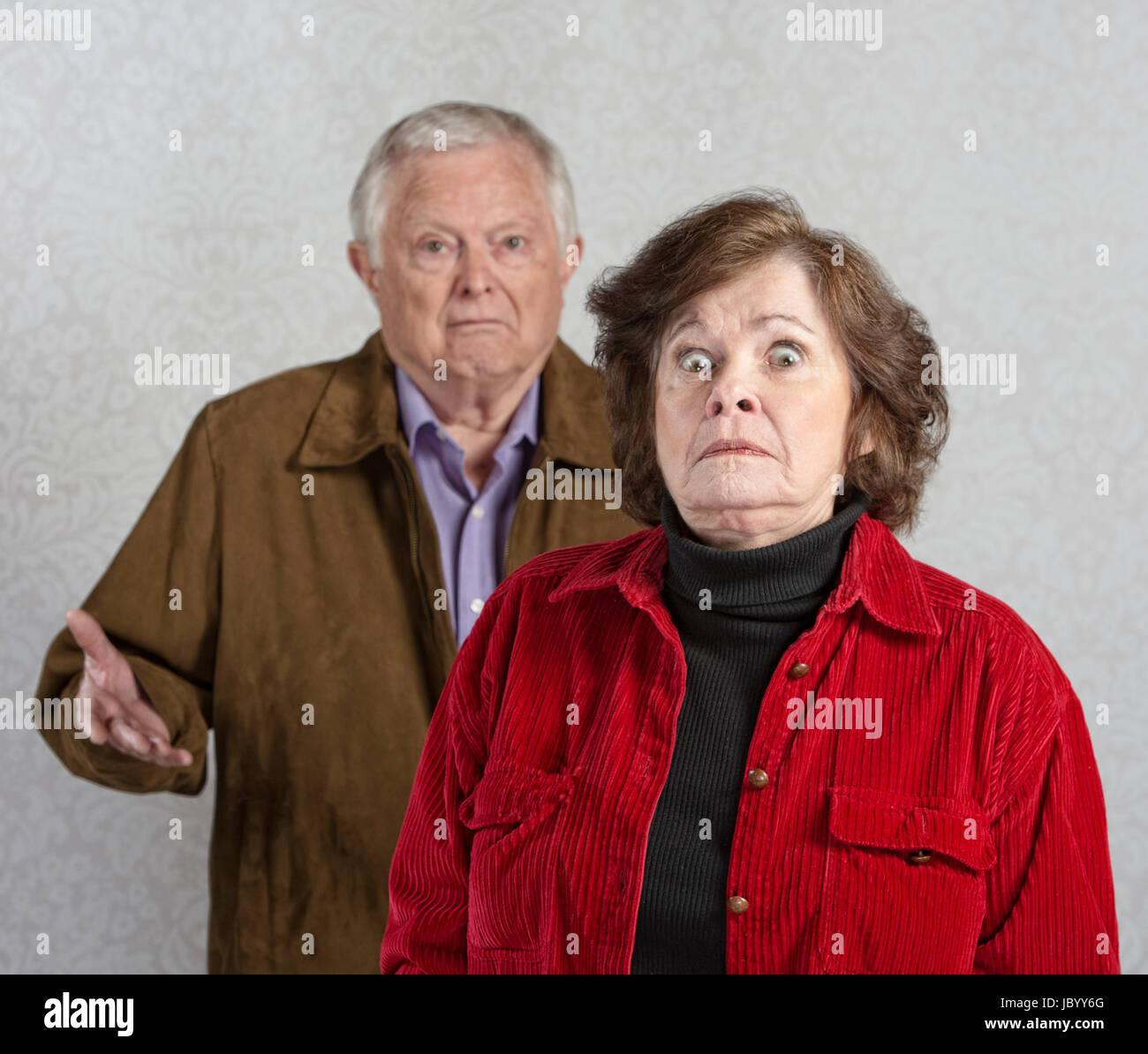 Stiff older woman in front of confused man Stock Photo