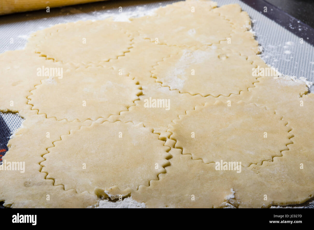 Rolled dough cut into circles for making apple fritters. Stock Photo