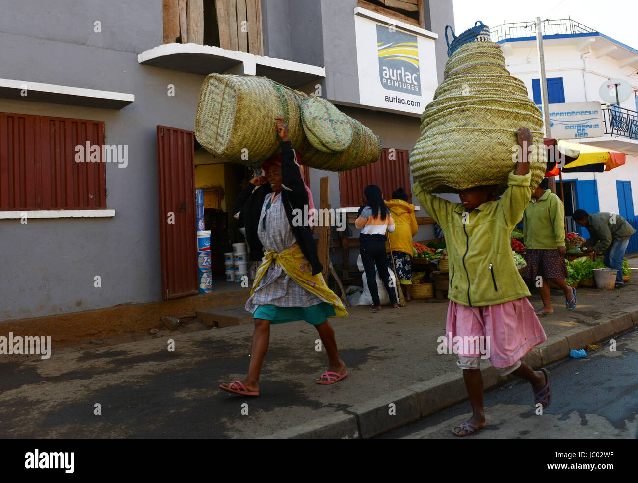Women carrying big baskets on their heads in central Madagascar. Stock Photo