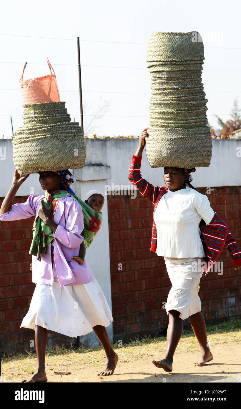 Women carrying big baskets on their heads in central Madagascar. Stock Photo