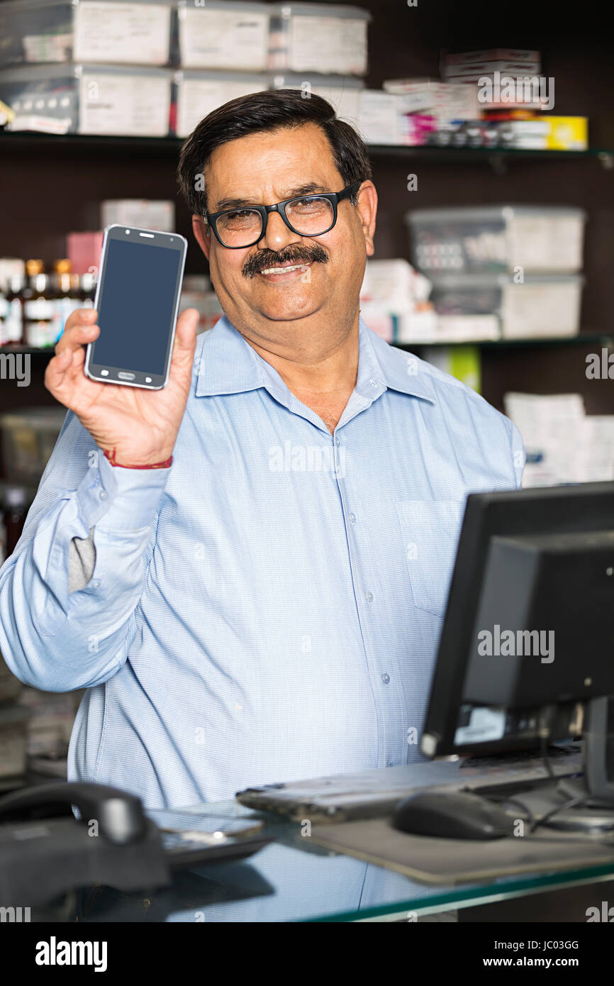 1 Indian Shop Keeper Man Showing New Mobile Phone In Chemist Store keeper  Stock Photo - Alamy