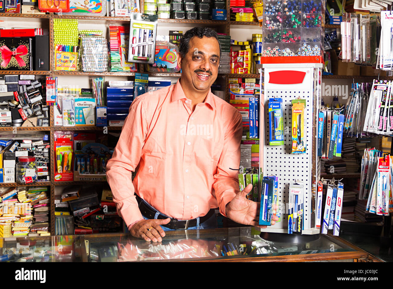 1 Indian Shopkeeper Man Showing Pens In Stationery Shop Stock Photo