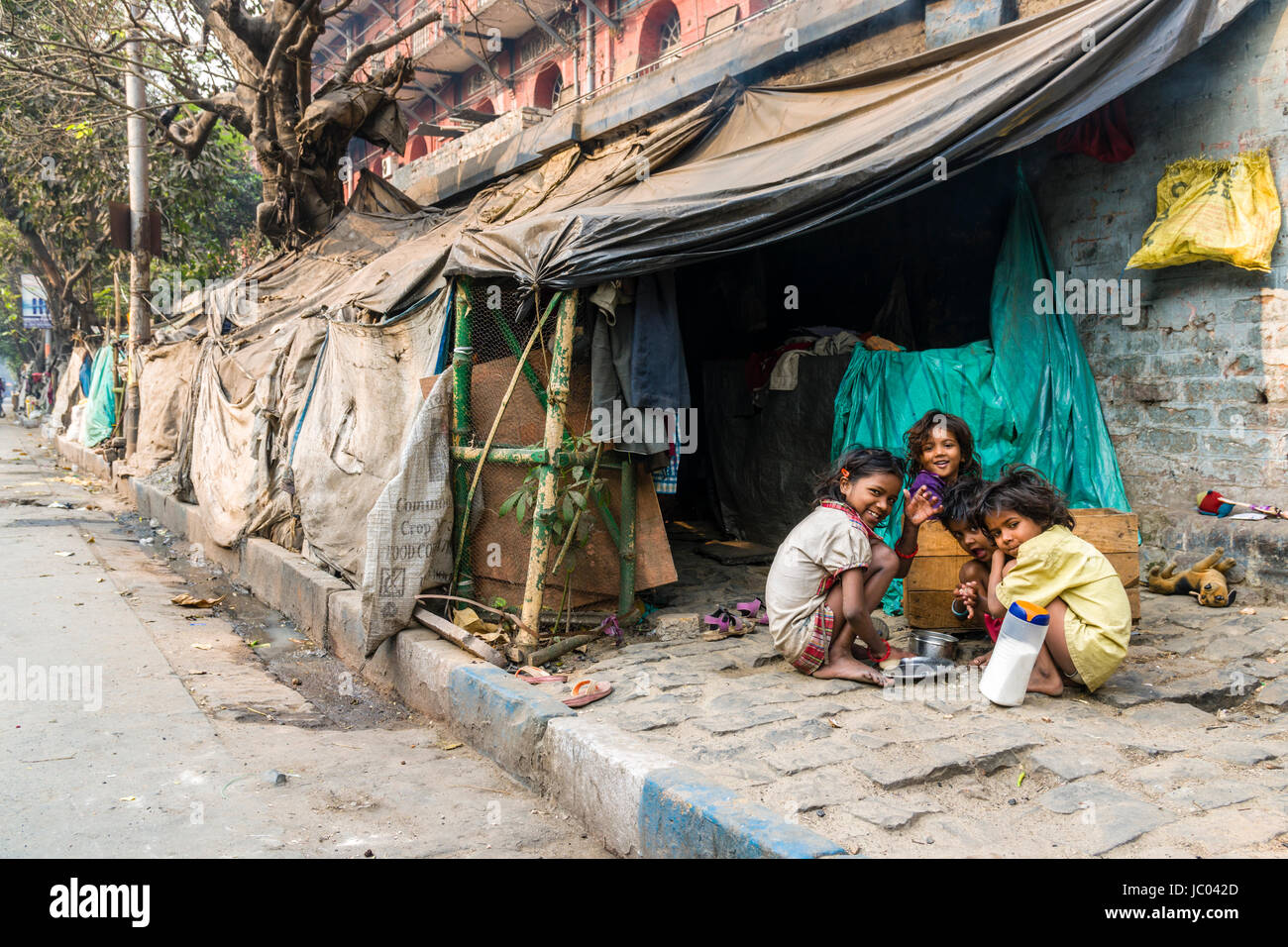 Children are sitting and playing in front of slum dwellings in the suburb China Bazar Stock Photo
