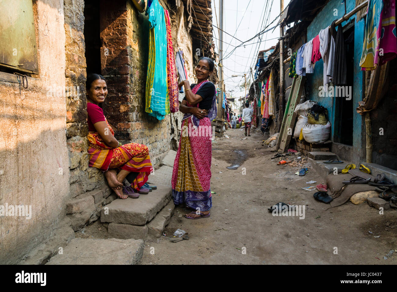 Two women in front of slum dwellings in Topsia slum Stock Photo