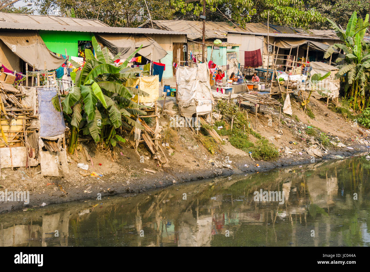 The dwellings and huts in Topsia slum are located at a dirty river Stock Photo