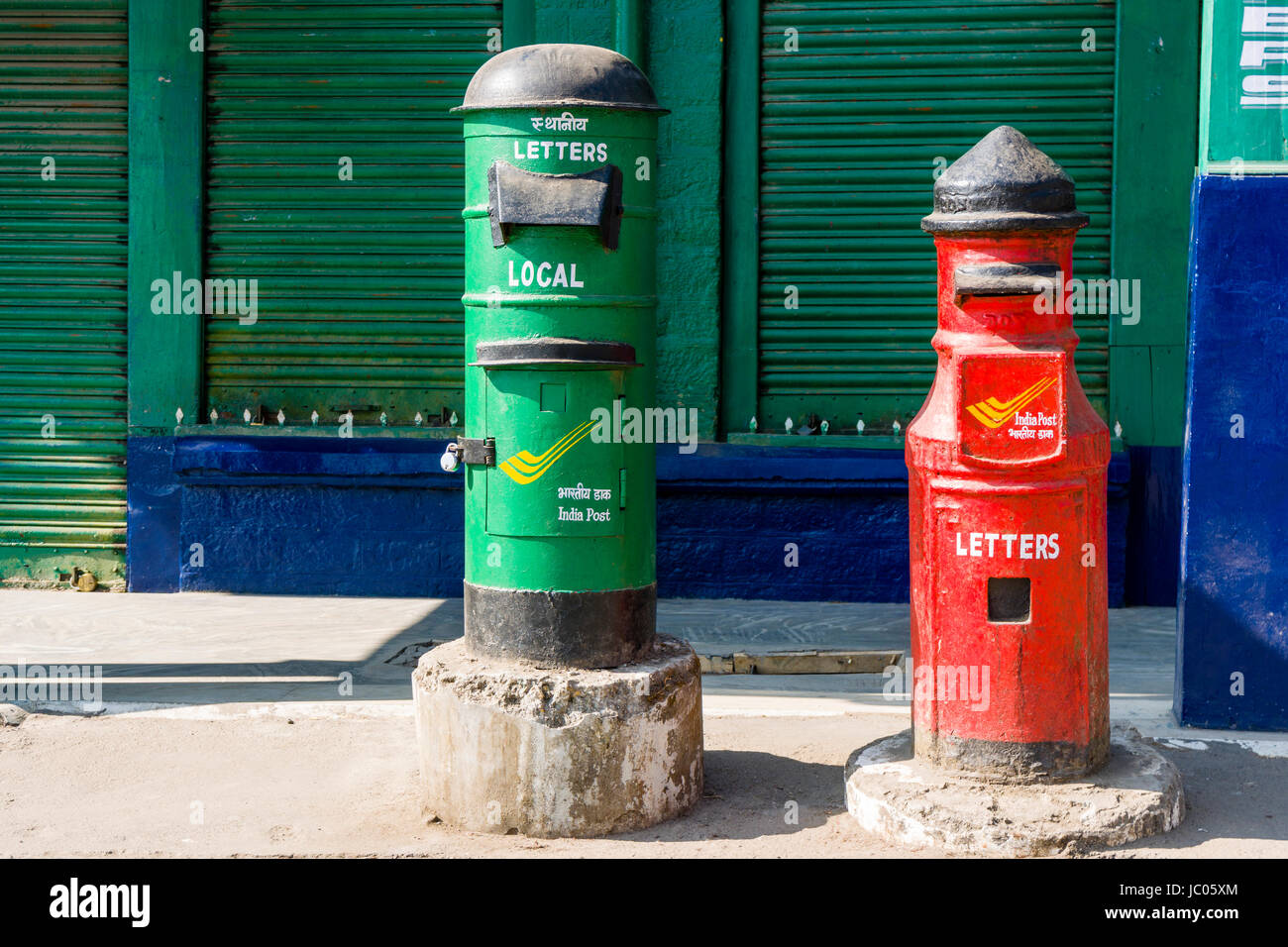A green and a red mailbox of the company India Post are located in the market area Stock Photo