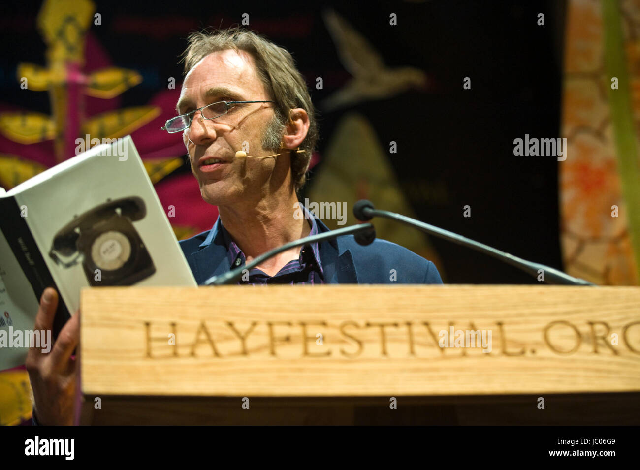 Will Self novelist reading from his novel Phone on stage at lectern during Hay Festival 2017 Hay-on-Wye Powys Wales UK Stock Photo