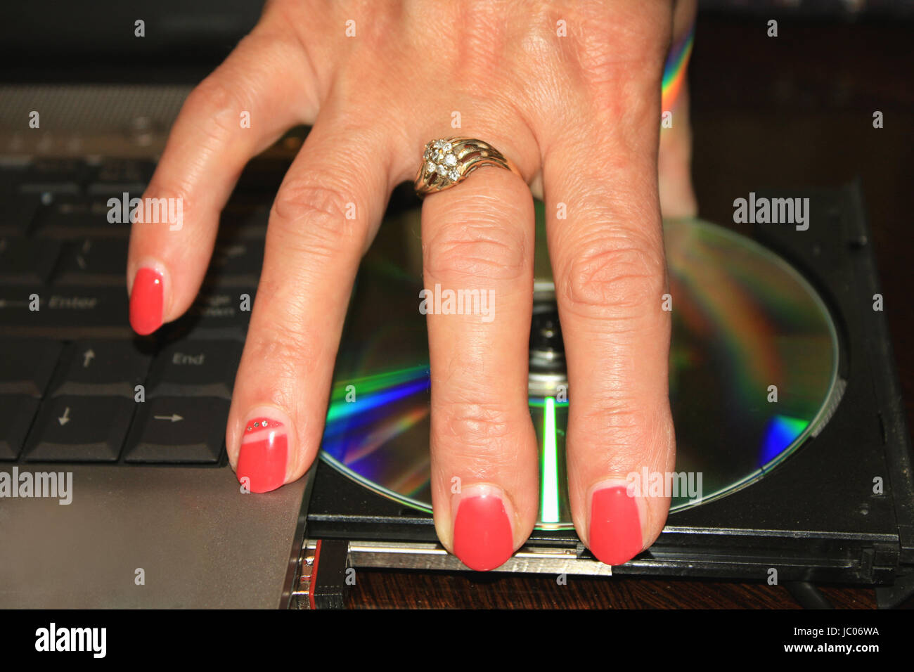 woman's hand with red nails taking DVD disc from PC Stock Photo Alamy