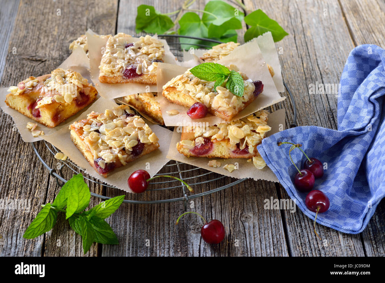 Fresh Austrian yeast cake with cherries and crunchy almond caramel served on a shabby cooling rack Stock Photo