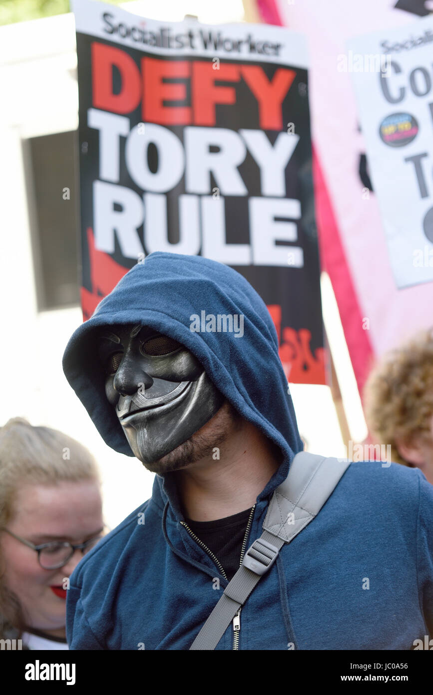 Demonstrators against the Tory DUP alliance gathered in Parliament Square and marched on Downing Street. London. Masked protester. Space for copy Stock Photo