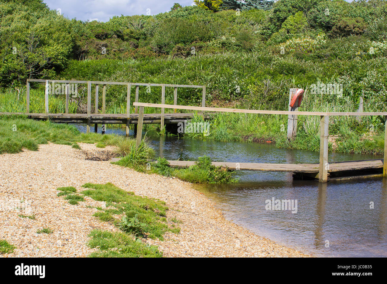 The remote wooden foot bridge on the Solent Way, Southampton Water at the end of the Hook Lane bridle path near Titchfield Common in Hampshire Stock Photo