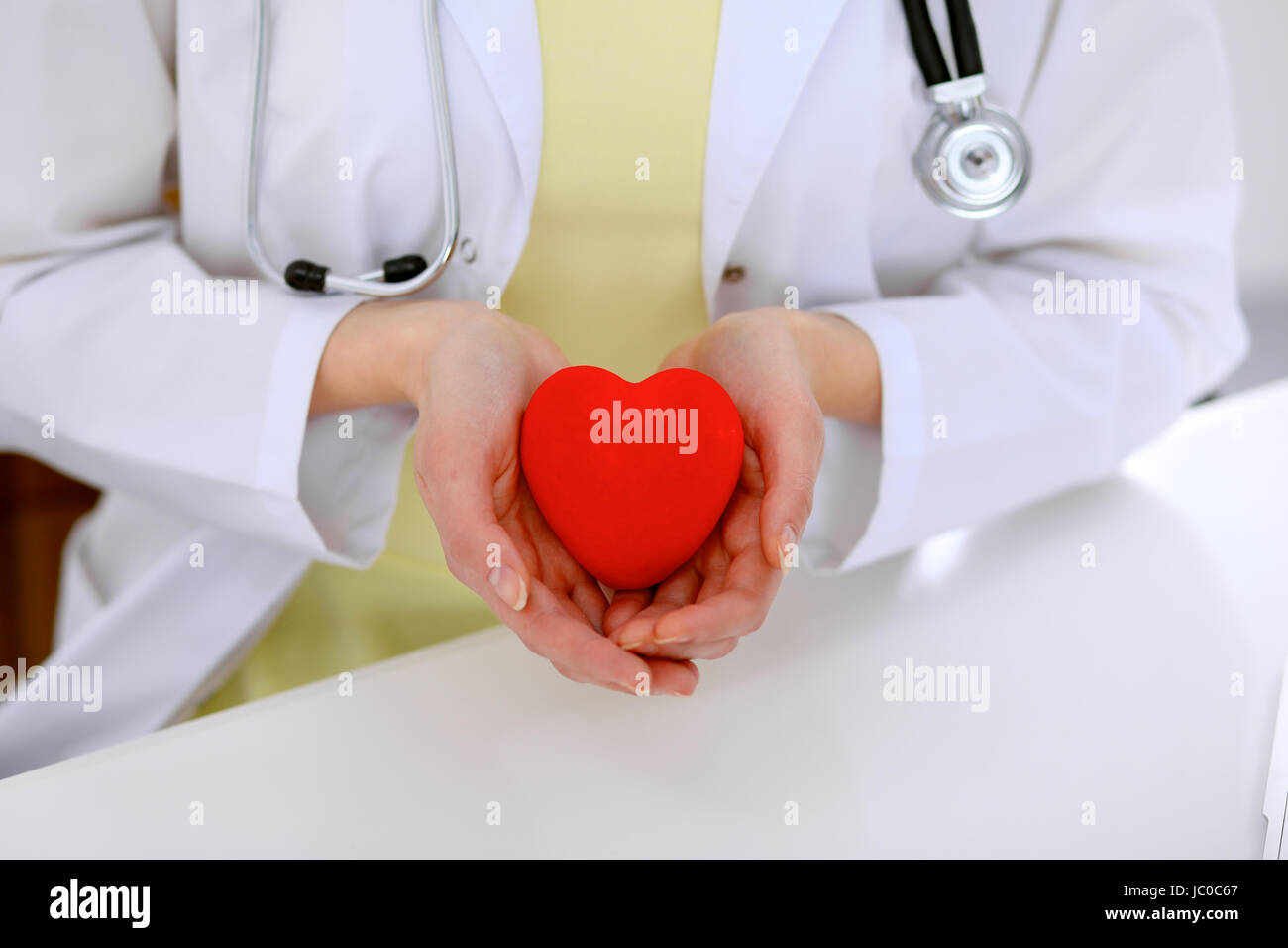 Female doctor with stethoscope holding heart Stock Photo - Alamy