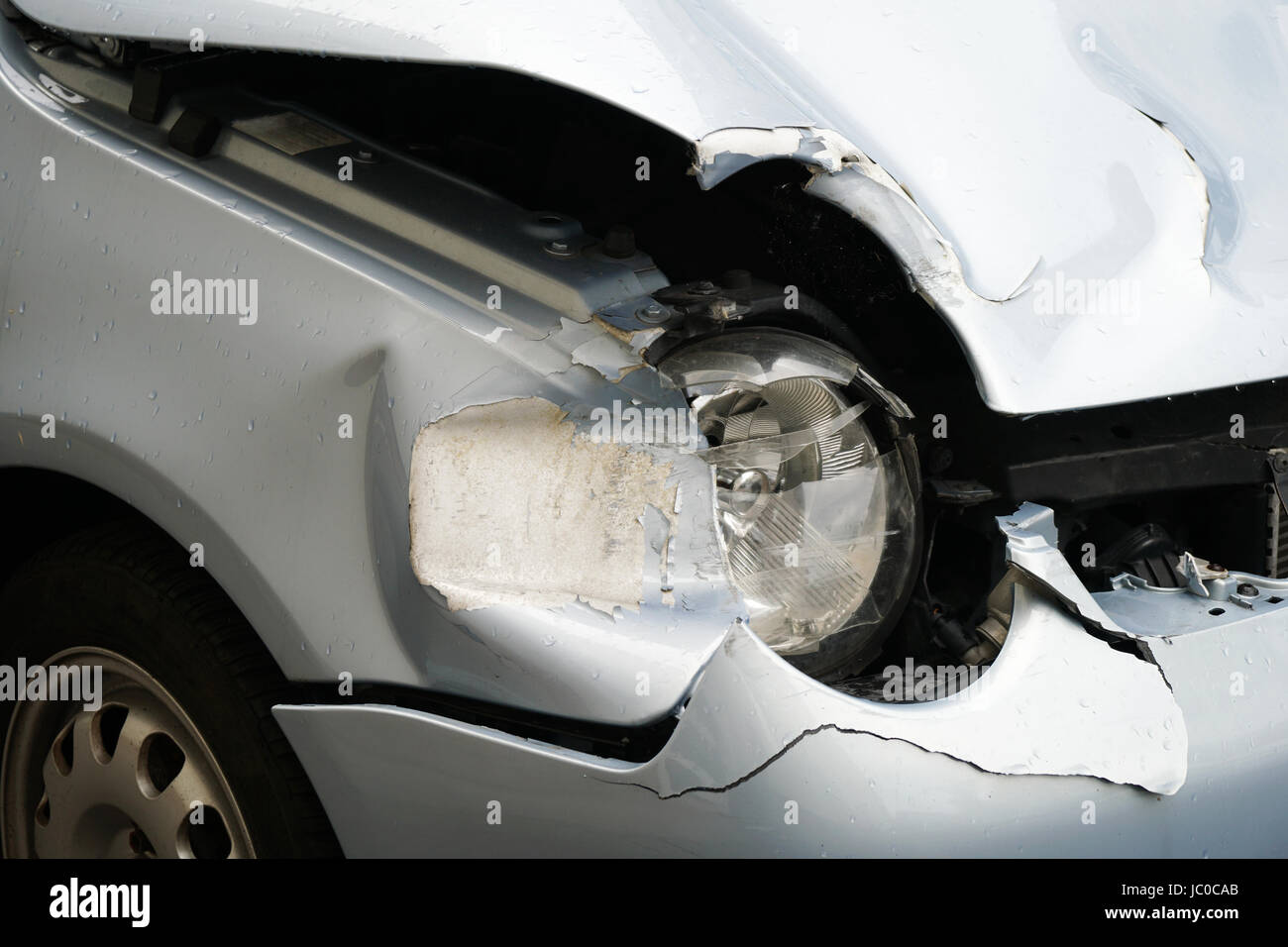 detail of car wreck after fender bender accident. broken headlight and