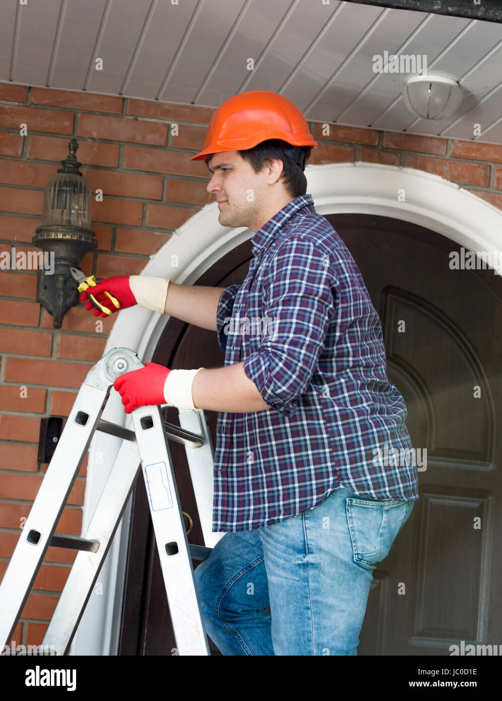 Man changing light bulb on ladder hires stock photography and images