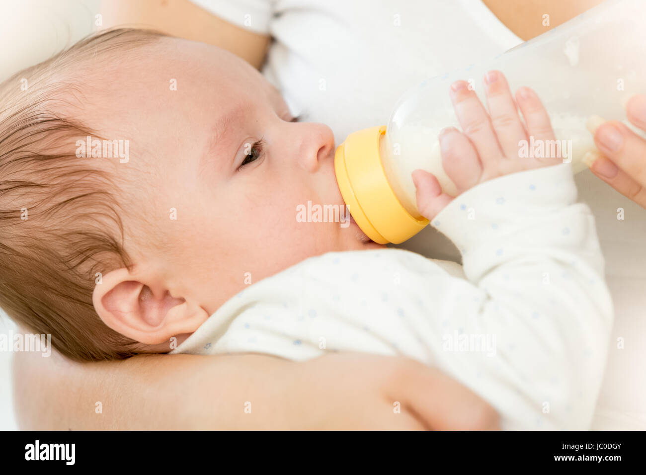 Closeup portrait of cute 3 months old baby boy drinking milk from