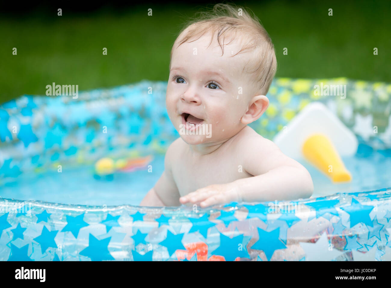 Portrait of cute 9 months old baby boy having fun in inflatable