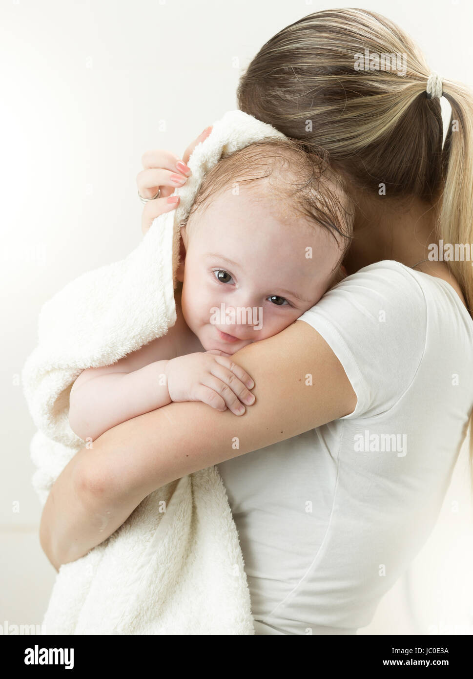 Portrait of cute baby boy hugging mother after having bath Stock Photo