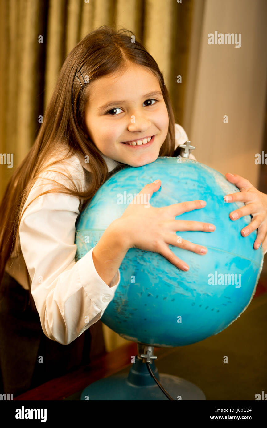 Portrait of cute schoolgirl holding big Earth globe Stock Photo - Alamy