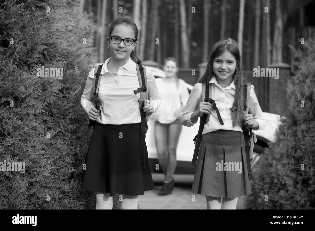 Black and white portrait of two cheerful girls going to school at morning Stock Photo