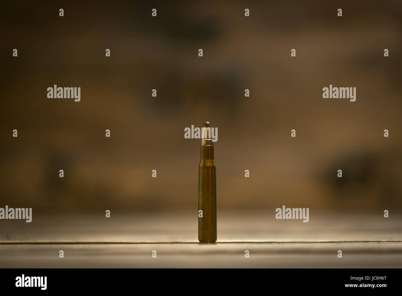 Macro shot of riffle bullet against dark wooden background Stock Photo