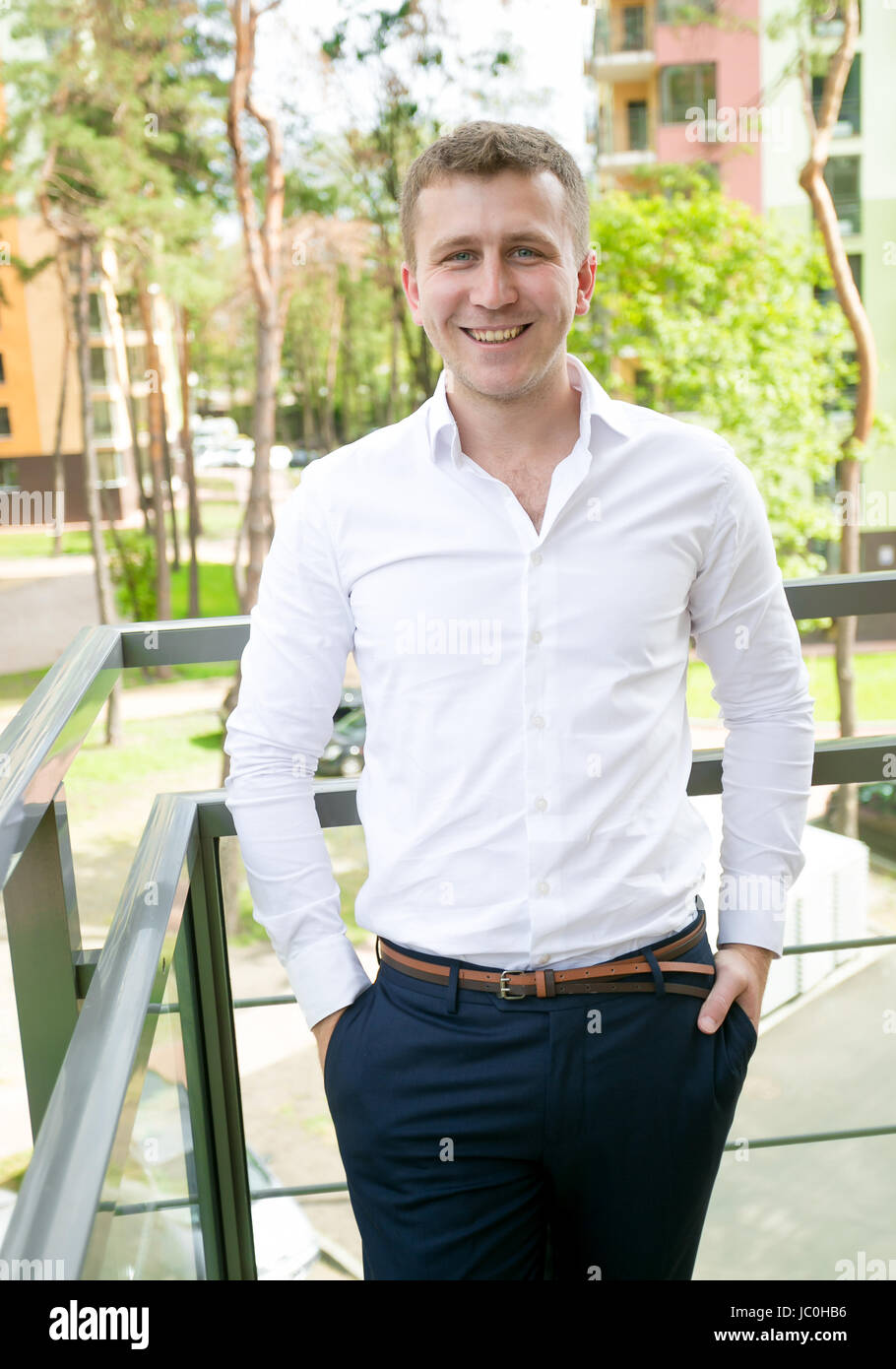 Portrait of handsome young businessman posing on balcony Stock Photo ...