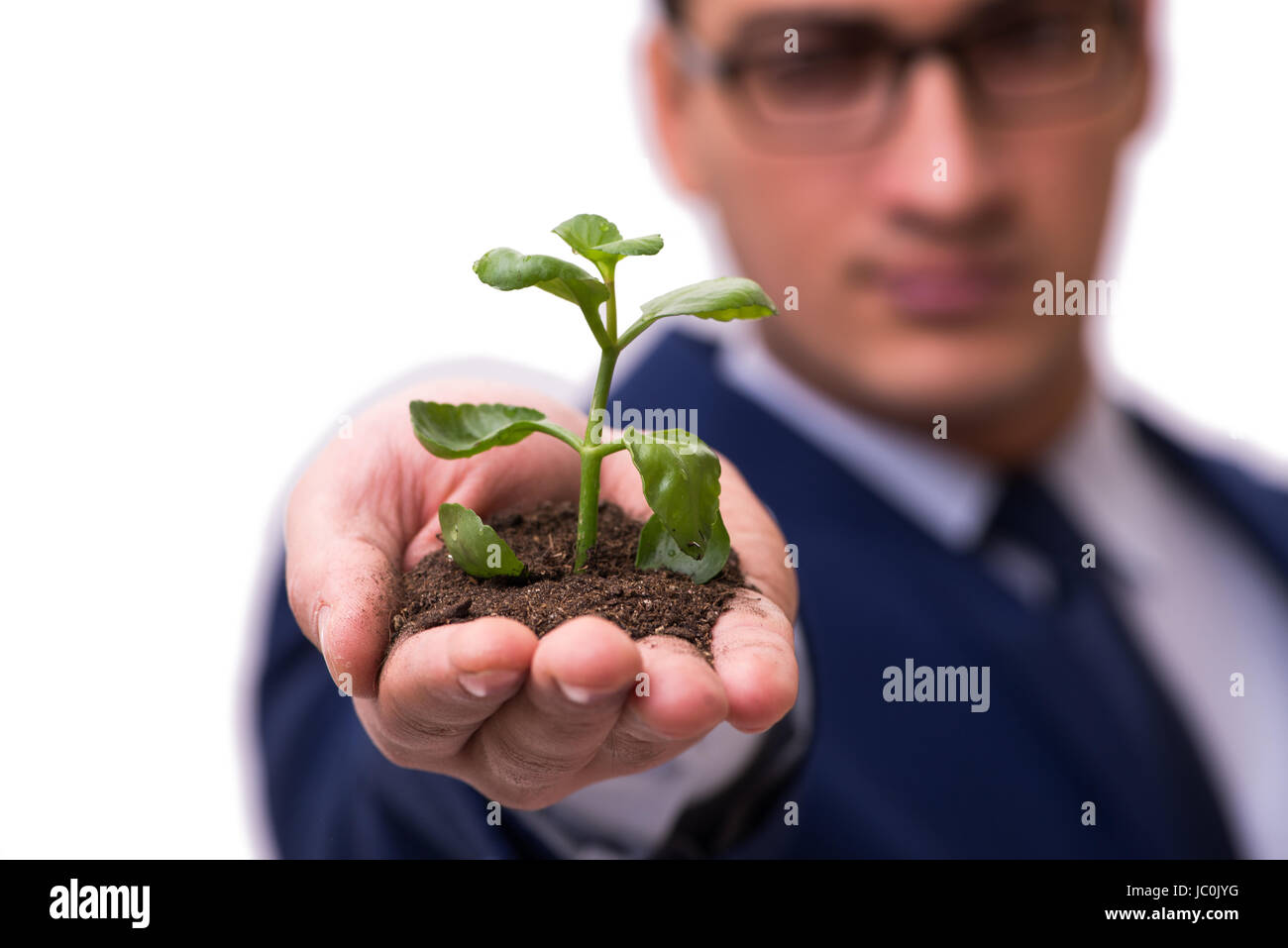 Businessman holding green sprouts isolated on white Stock Photo - Alamy