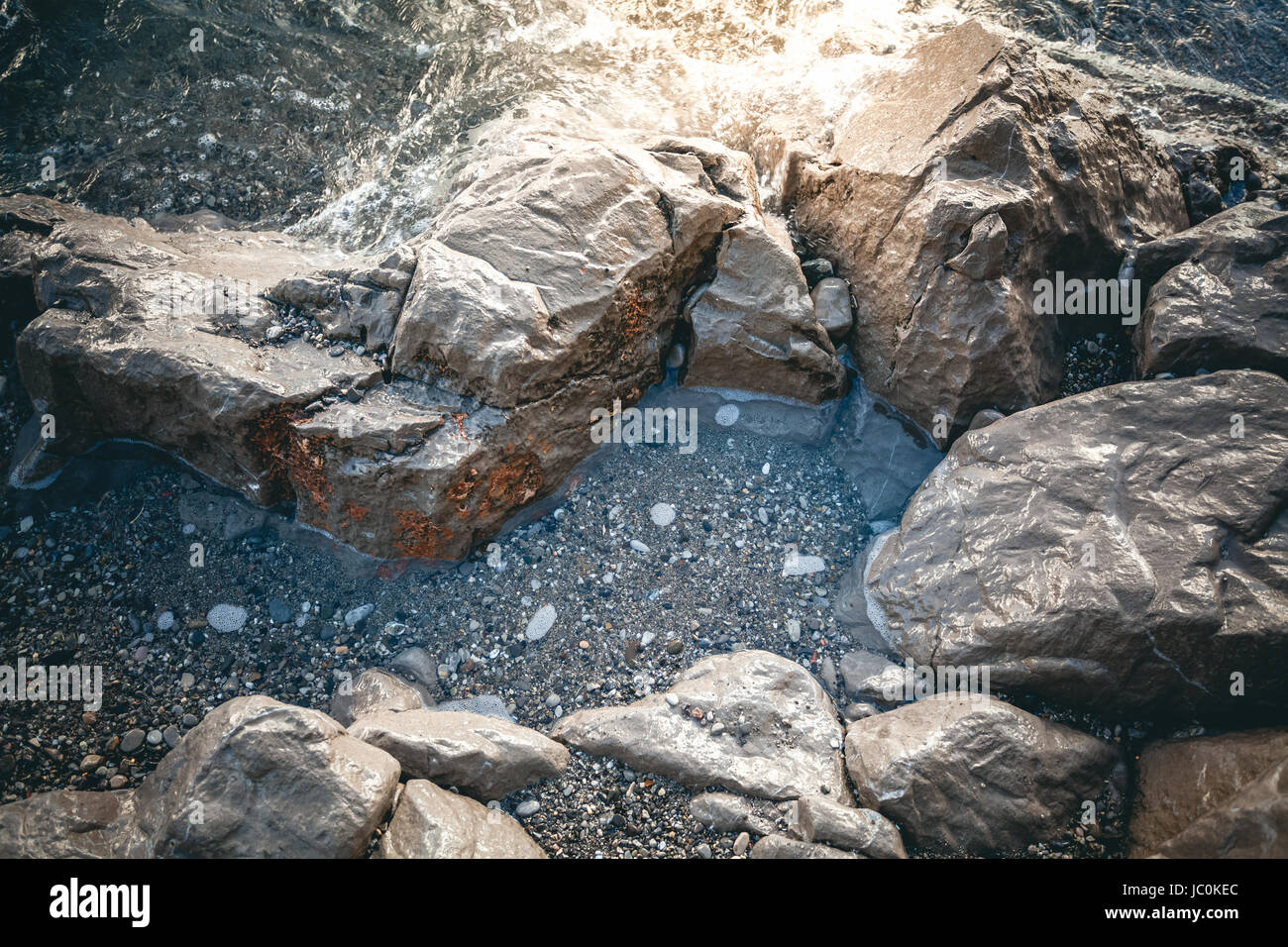 Closeup photo of gray rocks at sea shore at sunset Stock Photo - Alamy