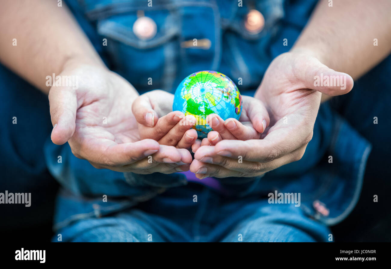 Closeup photo of man holding girls hands with earth globe Stock Photo ...