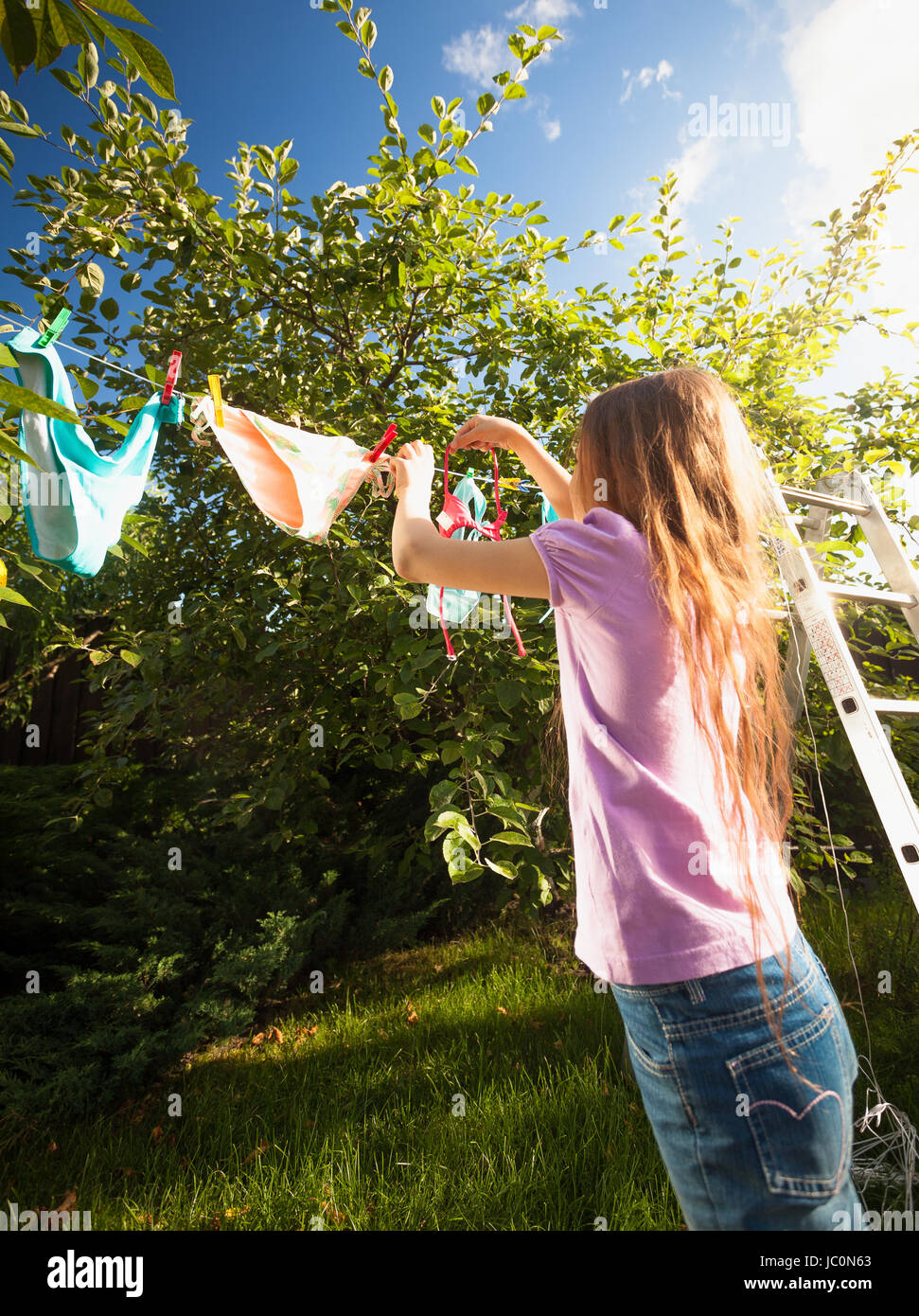 https://c8.alamy.com/comp/JC0N63/outdoor-shot-of-girl-doing-laundry-and-drying-clothes-at-garden-JC0N63.jpg