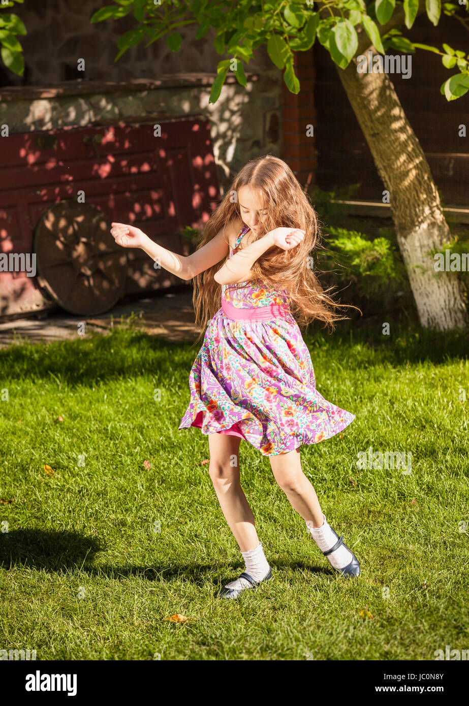 Beautiful young girl dancing on grass at sunny day Stock Photo - Alamy