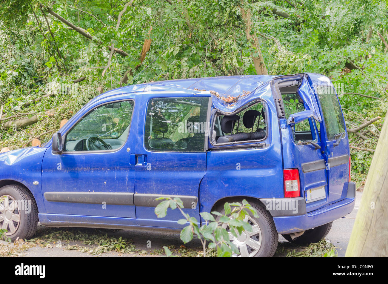 ESSEN, GERMANY - JUNI, 13.2014: Auto nach Sturmschaden Anfang Juni, nachdem ein großer Baum auf das Auto gefallen ist. Stock Photo