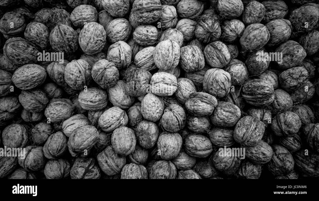 Closeup black and white texture of raw walnuts in shells Stock Photo