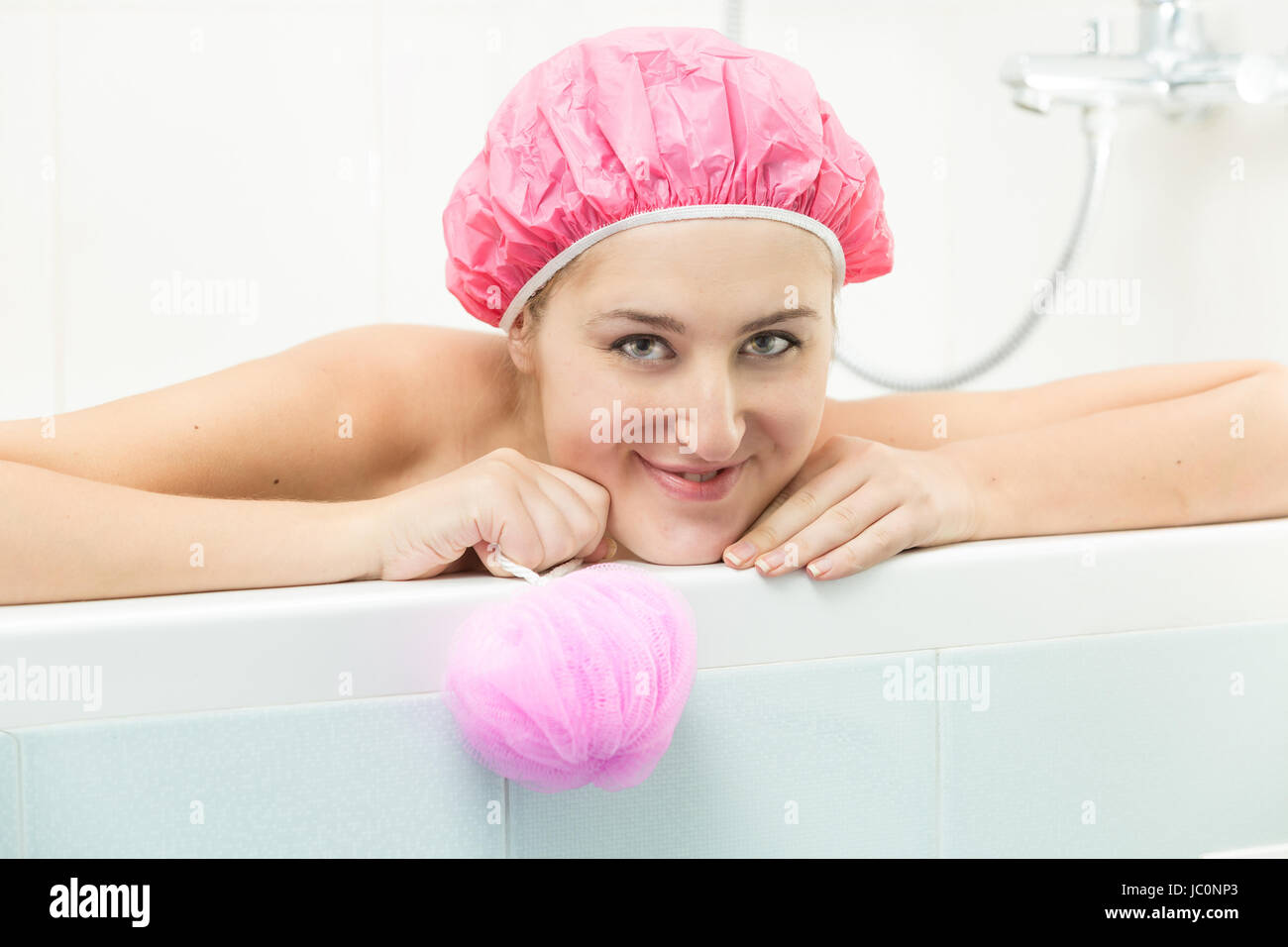 Beautiful smiling woman lying in bath and looking at camera Stock Photo