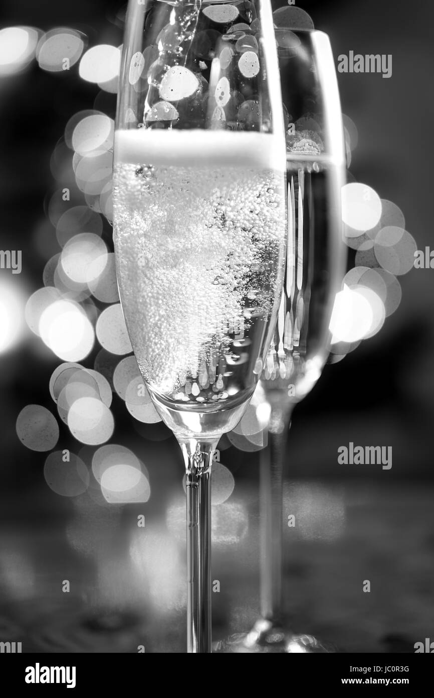 Macro black and white photo of champagne poured into glasses Stock Photo