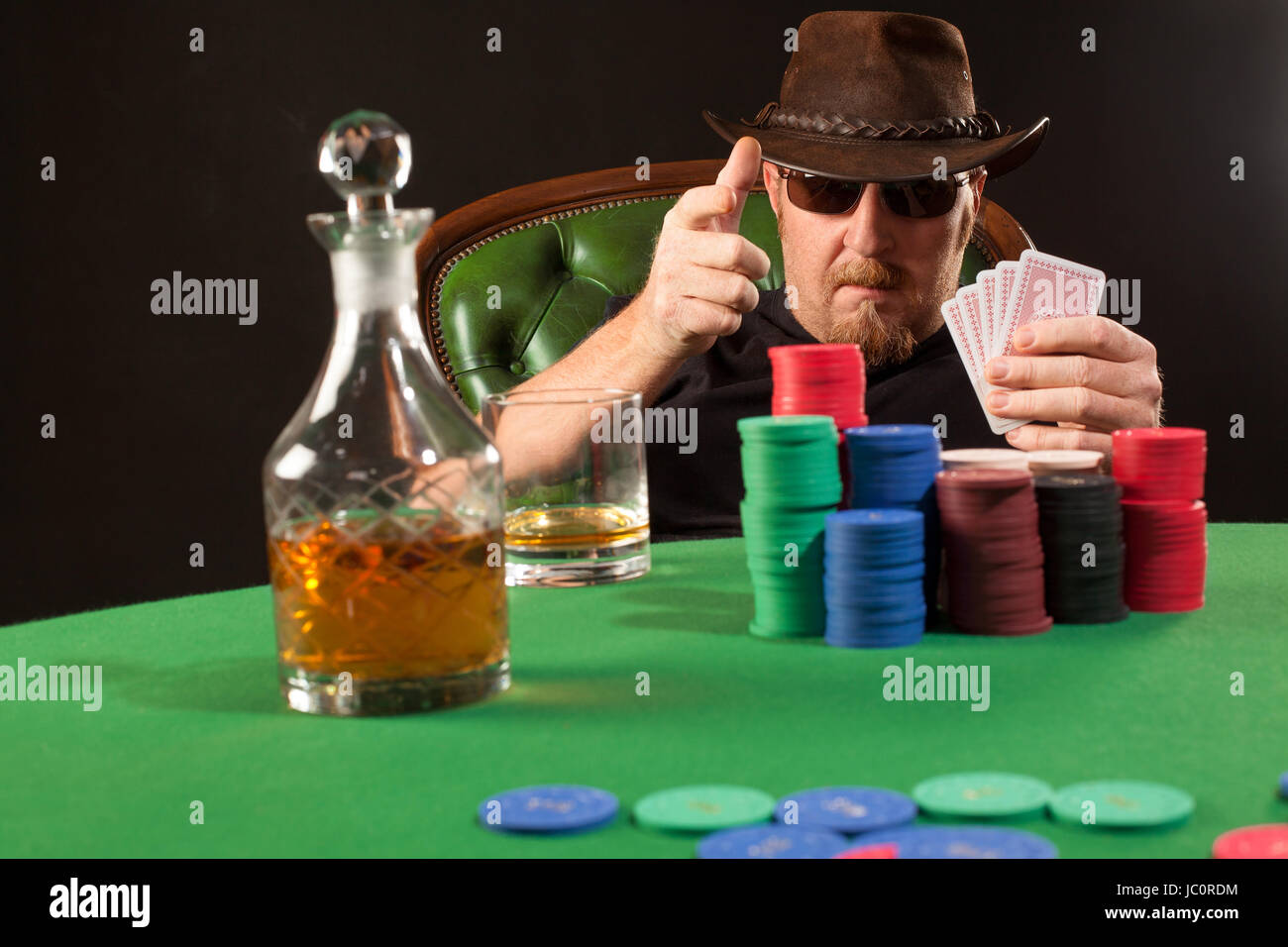 Photo of a man playing poker while wearing sunglasses and a hat Stock
