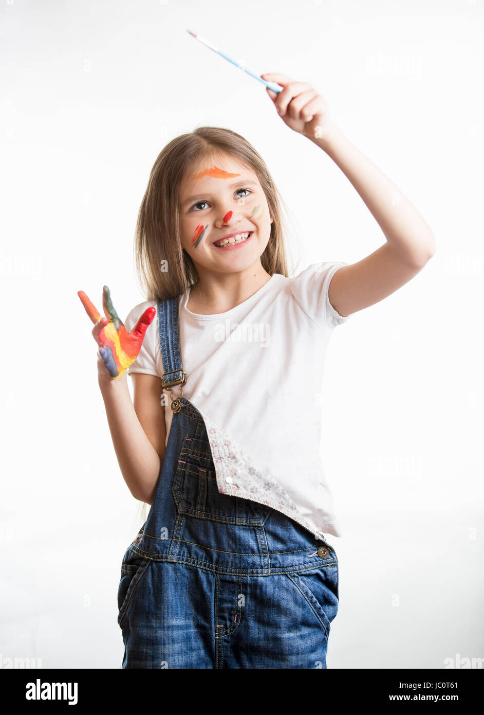 Happy little girl drawing in the air with paintbrush over white
