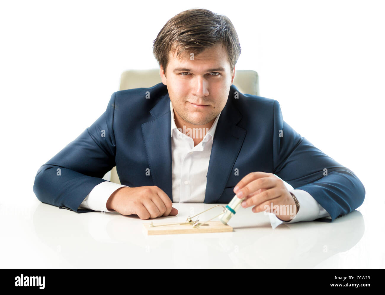 Portrait of cunning businessman putting money in trap as lure Stock Photo