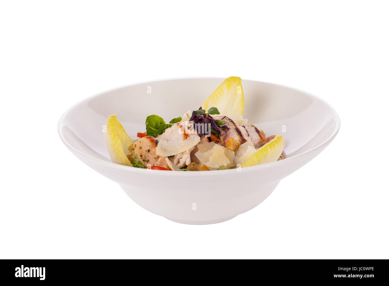 Frischer leckerer caesarsalat mit gegrillter Hähnchenbust parmesansplittern und croutons isoliert vor weißem Hintergrund Stock Photo