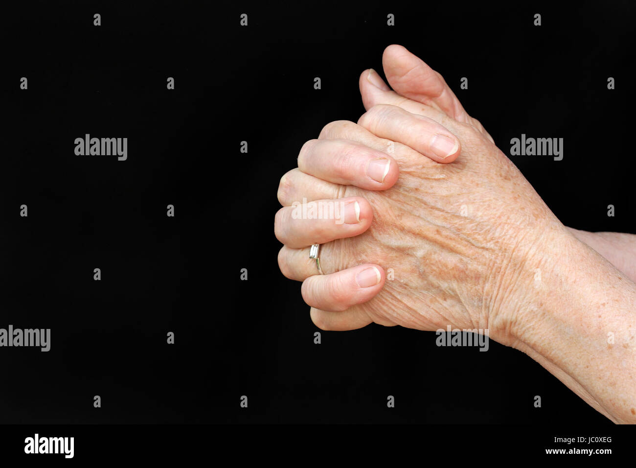 a praying old woman Stock Photo
