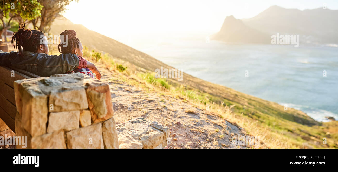 view of the ocean and mountains being admired by couple Stock Photo