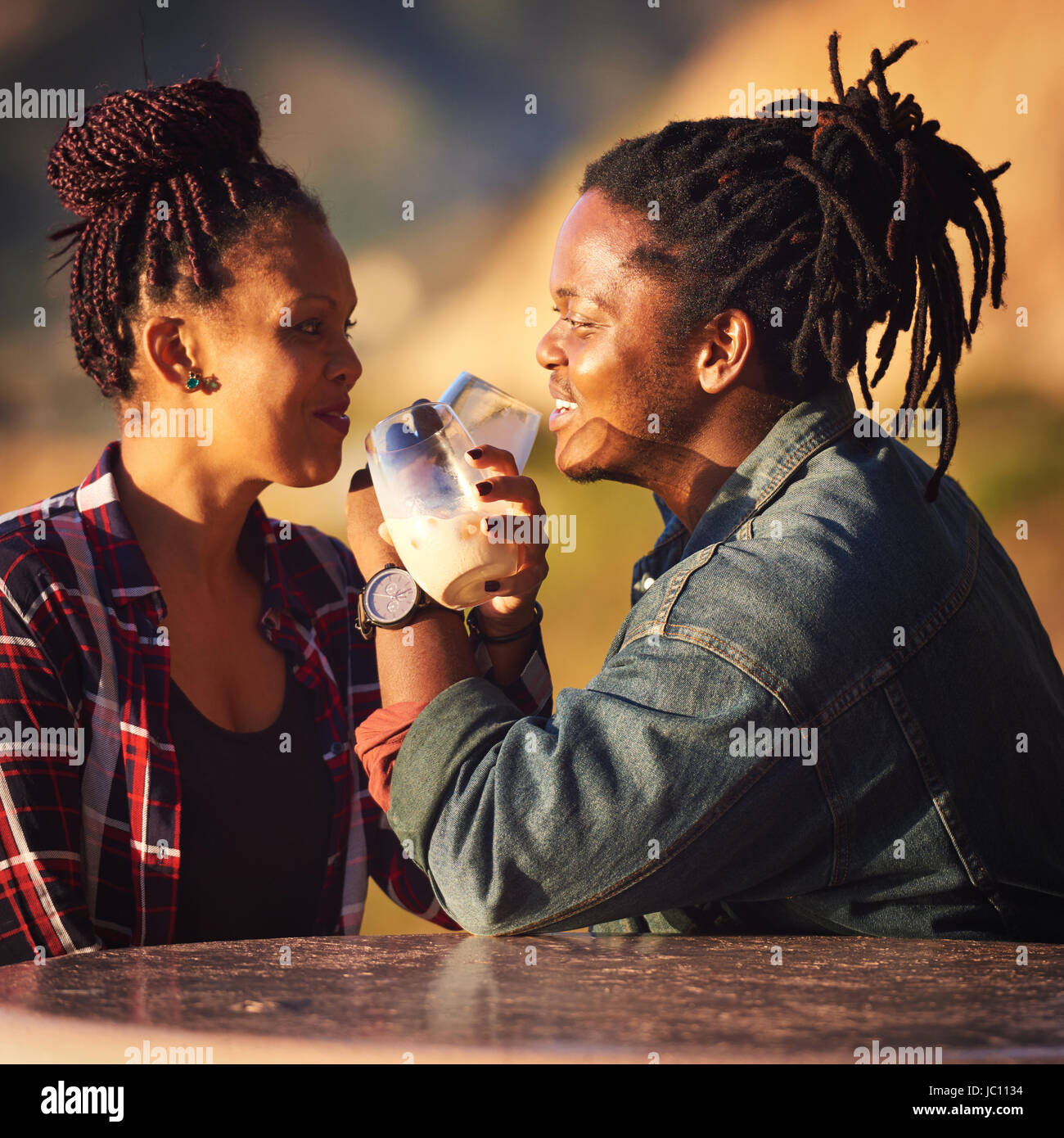 Mixed race couple of African descent making an intertwined toast Stock Photo