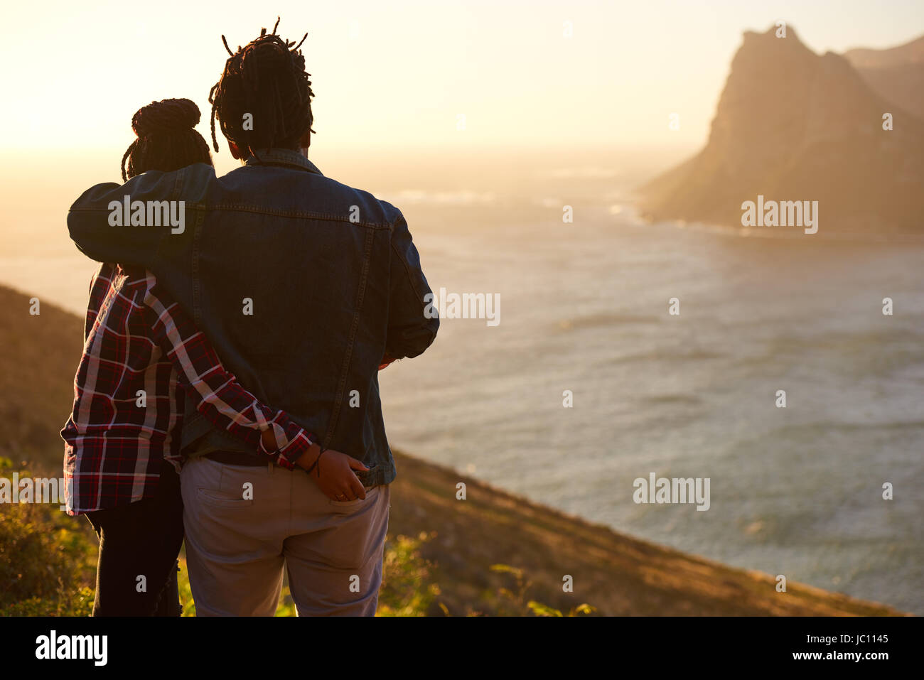 Mixed race couple standing together watching the view from behind Stock Photo