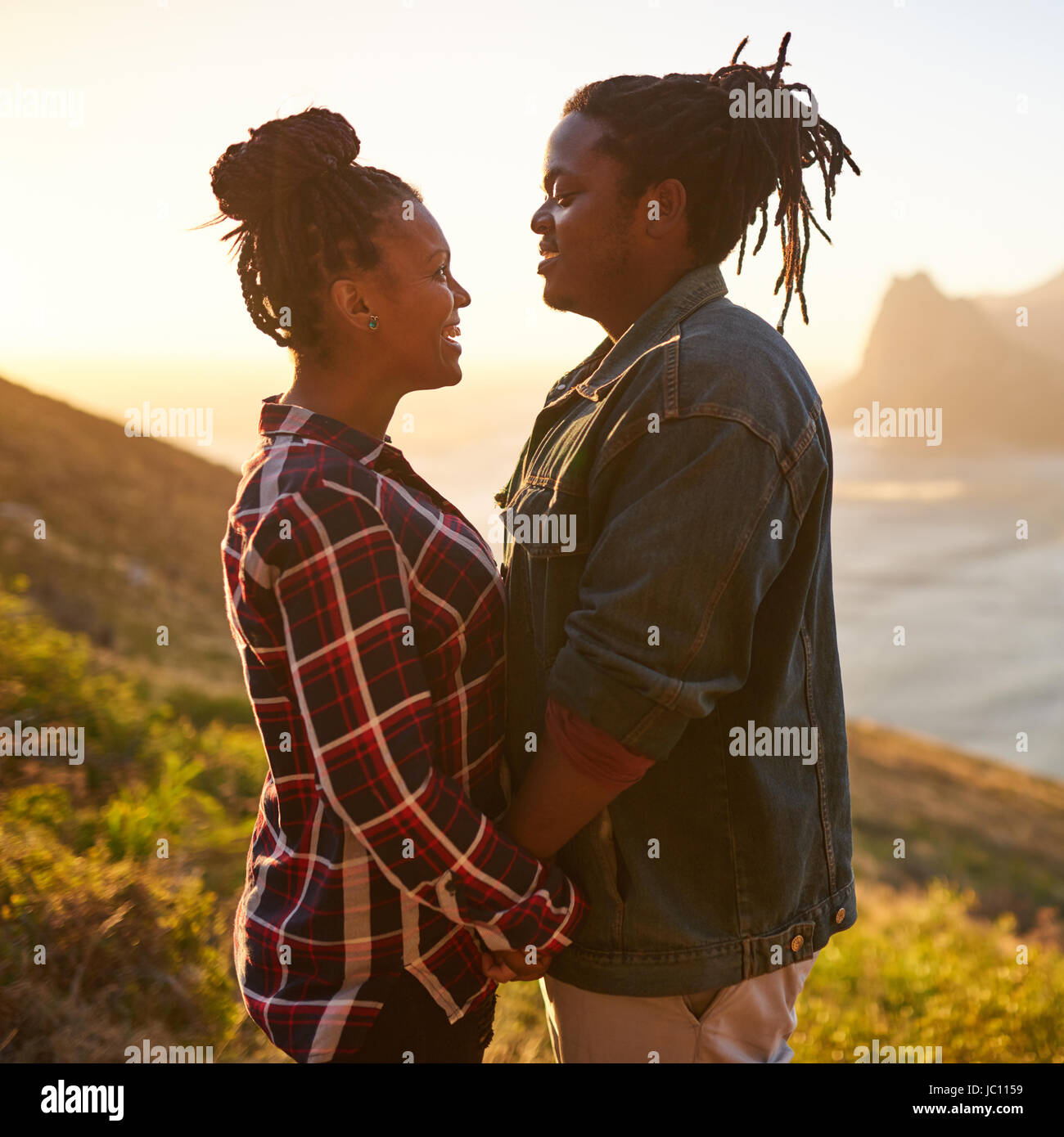 Mixed race couple holding hands outdoors in a beautiful landscape Stock Photo