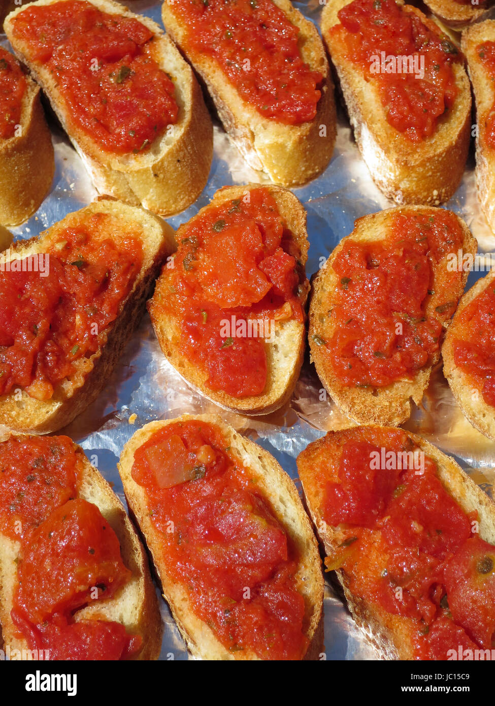 Pan of delicious bruschetta appetizers made by spreading the tomato-based bruschetta sauce on toasted french toast slices. Stock Photo