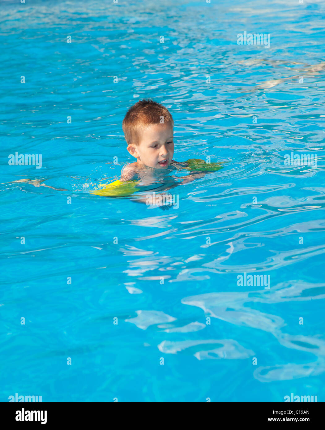 Happy boy swimming with floaties in swimming pool Stock Photo Alamy