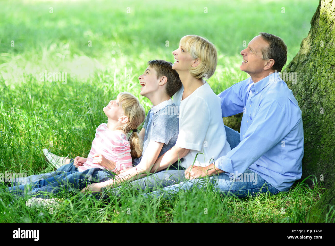 Cute couple sitting under tree hi-res stock photography and images - Alamy